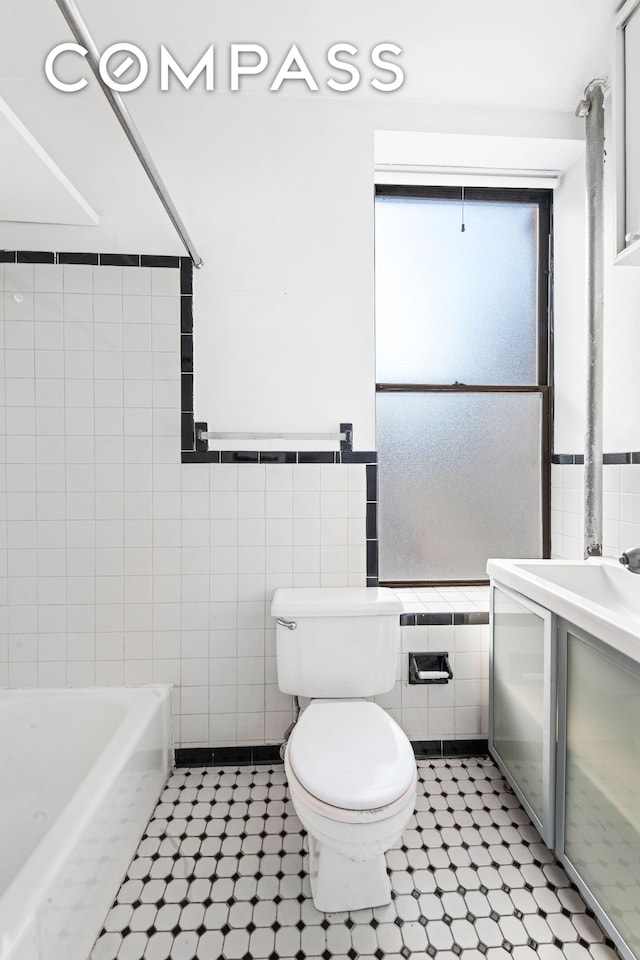 214 Mulberry St Unit 6B, New York City, NY 10012 - full bath with tile walls, a bath, vanity, and tile patterned flooring