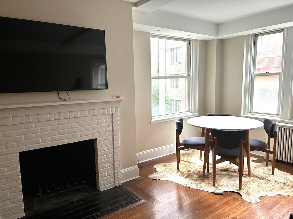 59 W 12th St Unit 4H, New York City, NY 10011 - dining area featuring wood finished floors, a fireplace, and radiator