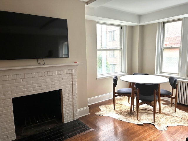 59 W 12th St Unit 4H, New York City, NY 10011 - dining area featuring wood finished floors, a fireplace, and radiator