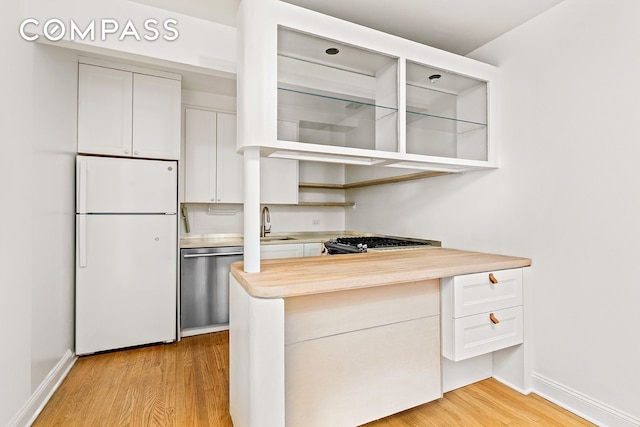 689 Fort Washington Ave Unit 1Aa, New York City, NY 10040 - kitchen with freestanding refrigerator, stainless steel dishwasher, open shelves, light wood-style floors, and light countertops