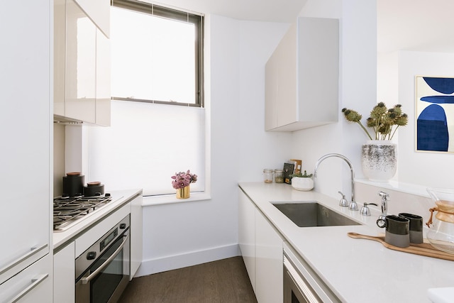 25 Broad St Unit 19-S, New York City, NY 10004 - kitchen featuring appliances with stainless steel finishes, white cabinets, modern cabinets, and light countertops