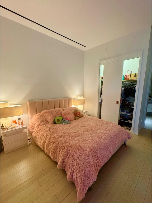 200 E 59th St Unit 8B, New York City, NY 10022 - bedroom with a walk in closet, light wood-type flooring, and a closet