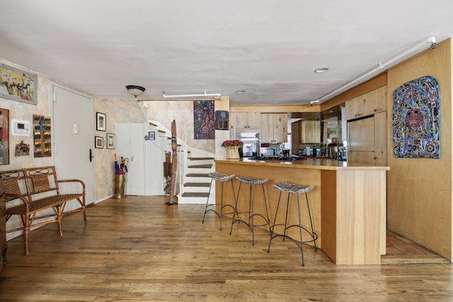 200 Mercer St Unit Ph4C, New York City, NY 10012 - kitchen with wall oven, wood finished floors, a kitchen breakfast bar, and freestanding refrigerator