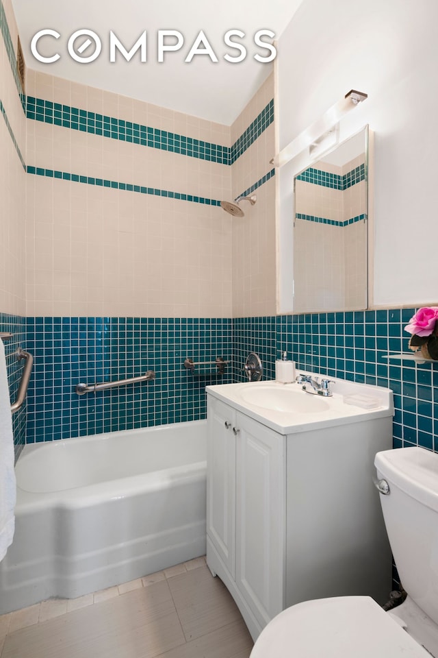 201 E 21st St Unit 15C, New York City, NY 10010 - bathroom featuring tile walls, vanity, shower / washtub combination, and tile patterned flooring