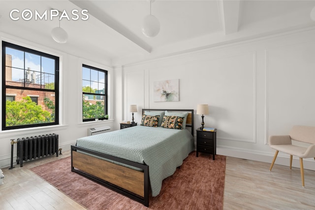 170 2nd Ave Unit 5C, New York City, NY 10003 - bedroom featuring radiator, a decorative wall, and wood finished floors