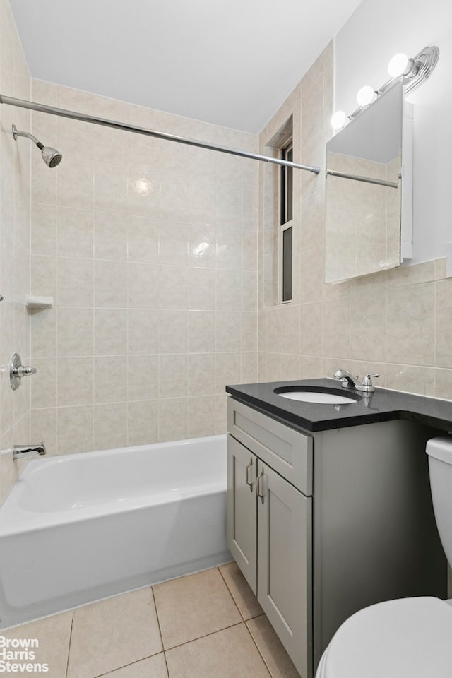 320 E 83rd St Unit 2B, New York City, NY 10028 - bathroom with tile patterned flooring, vanity, tile walls, and bathtub / shower combination