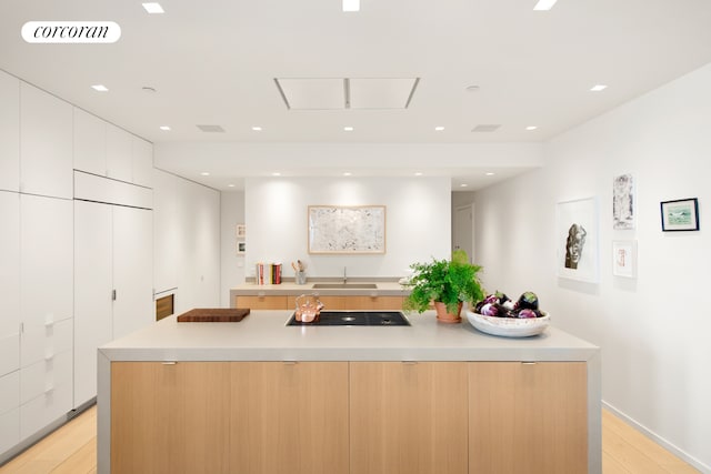 270 Broadway Unit 18C, New York City, NY 10007 - kitchen featuring modern cabinets, black electric stovetop, light wood-style flooring, and recessed lighting