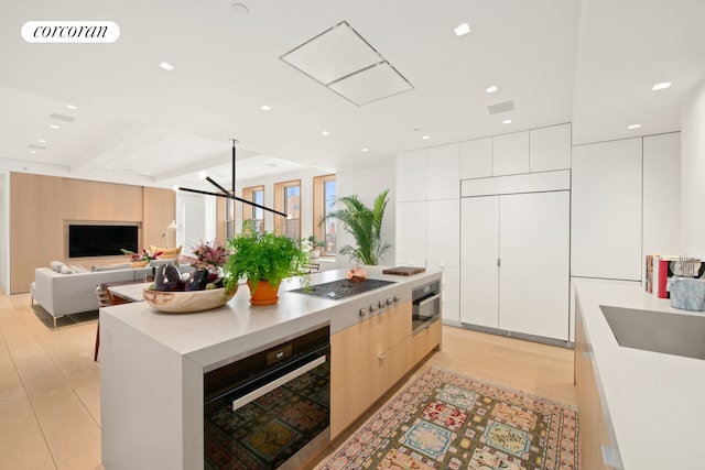 270 Broadway Unit 18C, New York City, NY 10007 - kitchen with modern cabinets, stainless steel appliances, light wood-type flooring, light countertops, and white cabinetry