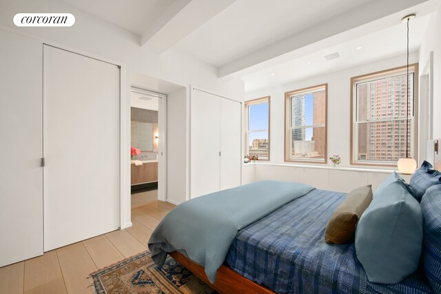 270 Broadway Unit 18C, New York City, NY 10007 - bedroom with beam ceiling, ensuite bath, and light wood-type flooring