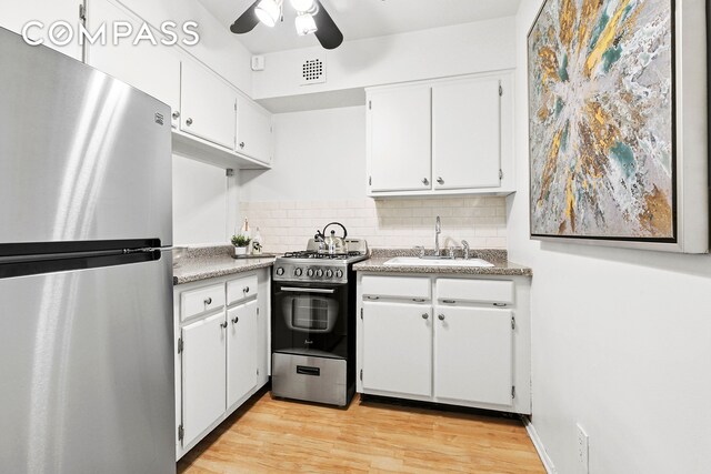 215 E 24th St Unit 412A, New York City, NY 10010 - kitchen featuring stainless steel appliances, ceiling fan, white cabinetry, and light wood-type flooring