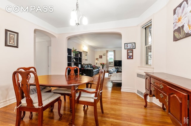79-15 35th Ave Unit 3E, New York City, NY 11372 - dining space featuring arched walkways, light wood finished floors, and radiator