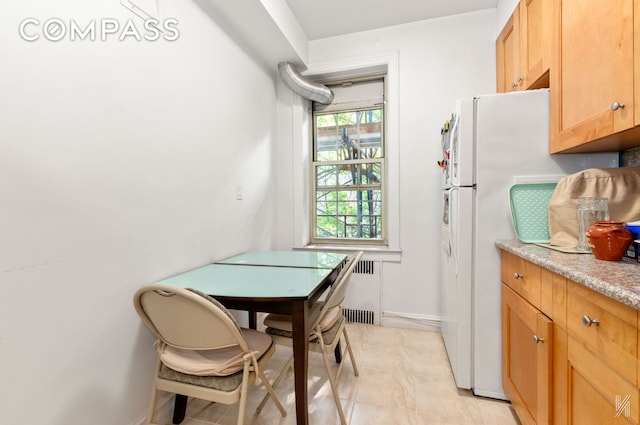 79-15 35th Ave Unit 3E, New York City, NY 11372 - kitchen featuring light tile patterned floors, light countertops, freestanding refrigerator, and radiator heating unit