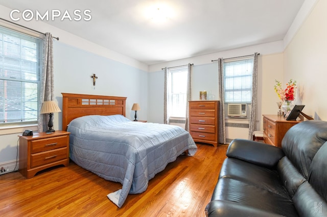 79-15 35th Ave Unit 3E, New York City, NY 11372 - bedroom featuring radiator, light wood finished floors, and cooling unit