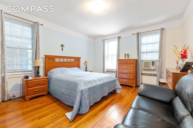 79-15 35th Ave Unit 3E, New York City, NY 11372 - bedroom with radiator, cooling unit, and light wood finished floors
