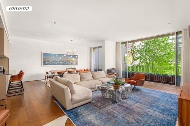 527 W 27th St Unit 3A, New York City, NY 10001 - living area with a chandelier, hardwood / wood-style flooring, and expansive windows