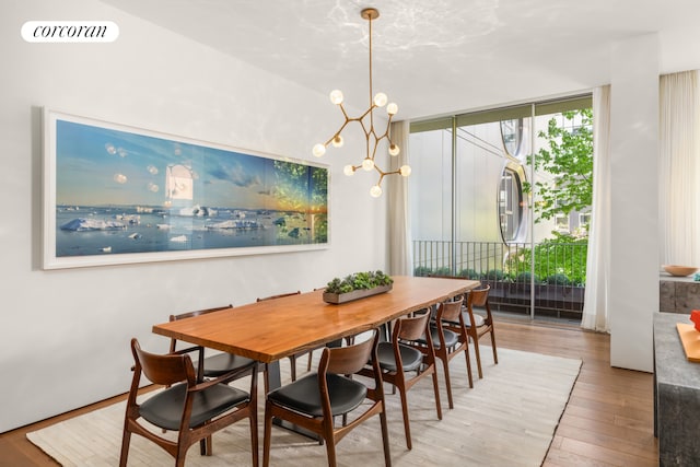 527 W 27th St Unit 3A, New York City, NY 10001 - dining room featuring hardwood / wood-style floors, a chandelier, and a wall of windows
