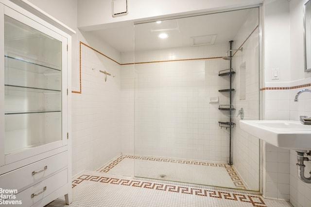 547 Broadway Unit 3, New York City, NY 10012 - full bathroom featuring tile walls, a tile shower, and tile patterned flooring
