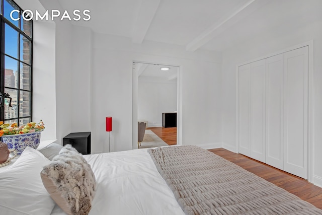 25 Tudor City Pl Unit 1405, New York City, NY 10017 - bedroom featuring wood finished floors, beam ceiling, and a closet