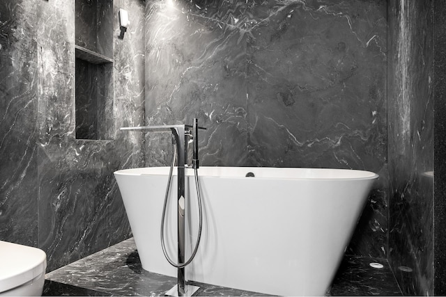 135 W 70th St Unit 10C, New York City, NY 10023 - bathroom featuring marble tiled floors, a soaking tub, and tile walls