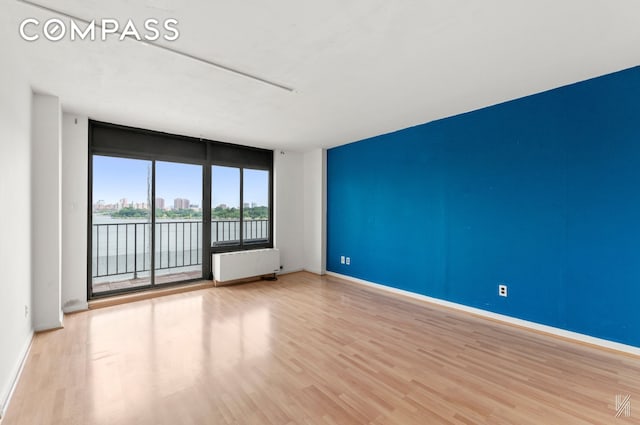 25-40 Shore Blvd Unit 4R, New York City, NY 11102 - empty room featuring radiator, wood finished floors, and a water view
