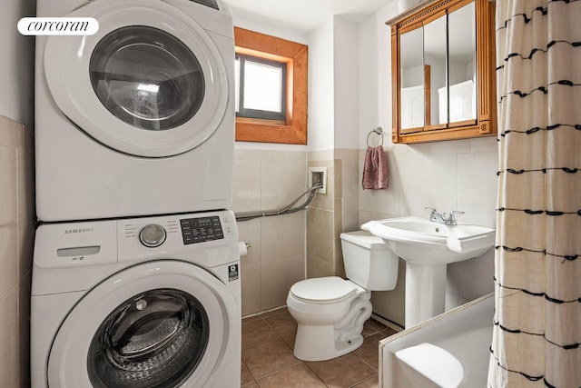 66 Putnam Ave, New York City, NY 11238 - full bathroom with stacked washer / drying machine, tile patterned flooring, curtained shower, tile walls, and a wainscoted wall