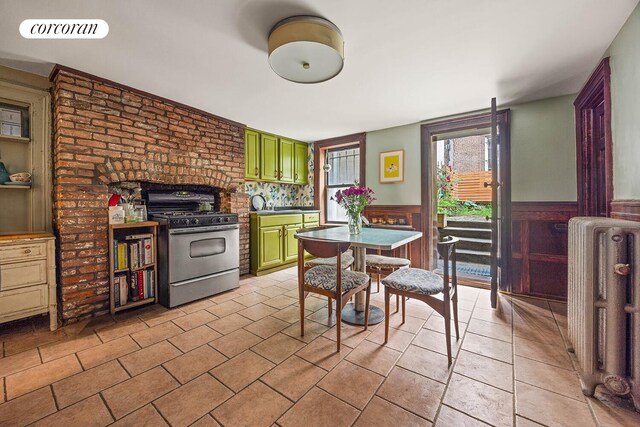 66 Putnam Ave, New York City, NY 11238 - dining space featuring radiator heating unit, wainscoting, and light tile patterned floors
