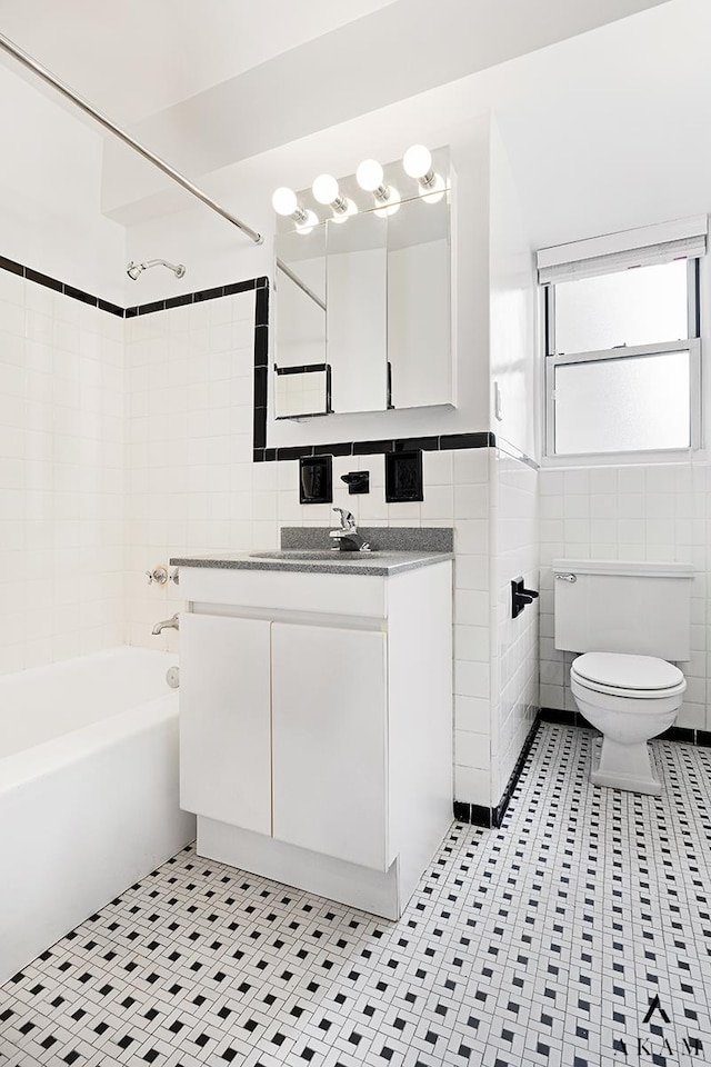 345 W 58th St Unit 8-D, New York City, NY 10019 - bathroom featuring tile walls, bathing tub / shower combination, vanity, and tile patterned floors