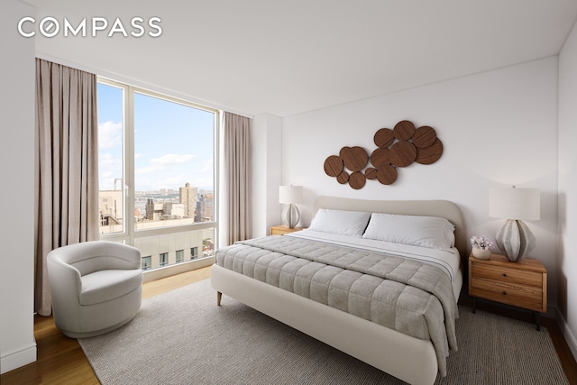 247 W 46th St Unit 3103, New York City, NY 10036 - bedroom with multiple windows, wood finished floors, expansive windows, and a view of city