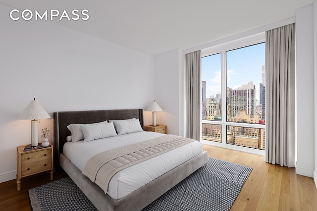 247 W 46th St Unit 3103, New York City, NY 10036 - bedroom featuring light wood-type flooring and a view of skyline