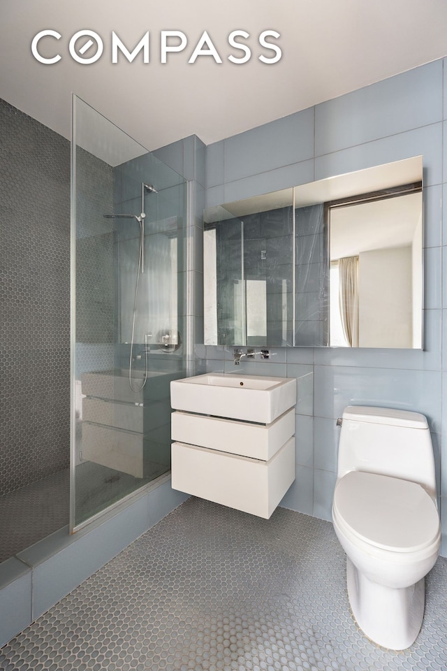 247 W 46th St Unit 3103, New York City, NY 10036 - full bath with tile walls, a shower stall, vanity, and tile patterned flooring