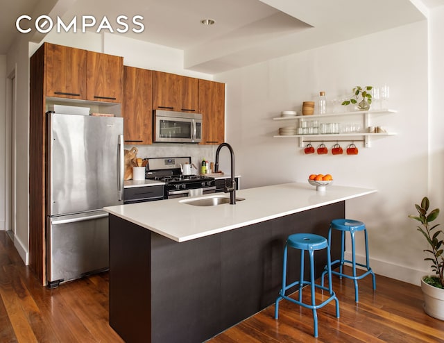161 Jackson St Unit 1, New York City, NY 11211 - kitchen featuring stainless steel appliances, brown cabinets, dark wood-style flooring, a breakfast bar, and a peninsula