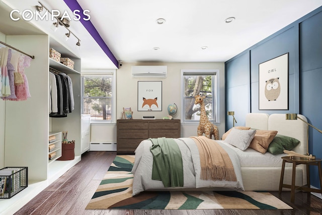 170 Skillman Ave, New York City, NY 11211 - bedroom featuring a wall unit AC, a baseboard radiator, wood finished floors, and recessed lighting