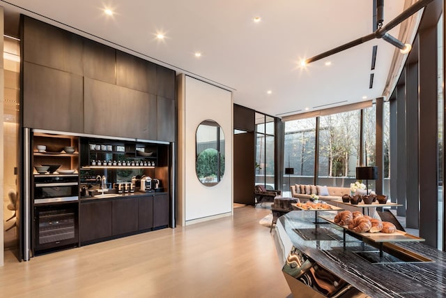 111 Murray St Unit 30A, New York City, NY 10007 - bar with a wall of windows, beverage cooler, light wood-style flooring, stainless steel oven, and recessed lighting