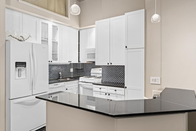 310 E 46th St Unit 4L, New York City, NY 10017 - kitchen featuring white appliances, dark countertops, white cabinets, tasteful backsplash, and glass insert cabinets