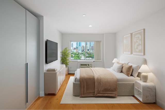 378 Baltic St Unit 9C, New York City, NY 11201 - bedroom featuring light wood-type flooring, a wall unit AC, recessed lighting, and a baseboard heating unit