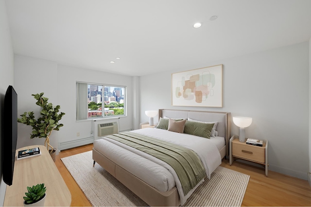 378 Baltic St Unit 9C, New York City, NY 11201 - bedroom featuring baseboard heating, light wood-style flooring, a wall mounted AC, and recessed lighting