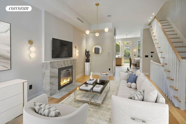 824A Quincy St, New York City, NY 11221 - living room with stairway, a high end fireplace, wood finished floors, and recessed lighting