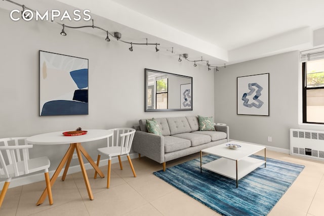 342 E 53rd St Unit 1G, New York City, NY 10022 - living area featuring radiator heating unit, track lighting, and light tile patterned floors
