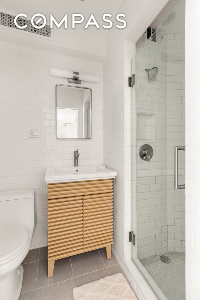 342 E 53rd St Unit 1G, New York City, NY 10022 - bathroom featuring tile patterned floors, a stall shower, vanity, and tile walls