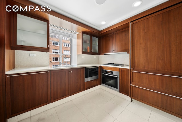140 E 63rd St Unit 9E, New York City, NY 10065 - kitchen featuring oven, light countertops, backsplash, glass insert cabinets, and recessed lighting
