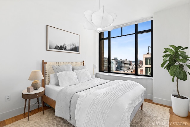 110 Charlton St Unit 17C, New York City, NY 10014 - bedroom with wood finished floors and a city view