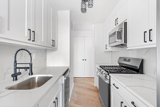 1655 Flatbush Ave Unit B1812, New York City, NY 11210 - kitchen featuring appliances with stainless steel finishes, tasteful backsplash, white cabinets, light wood finished floors, and light stone countertops