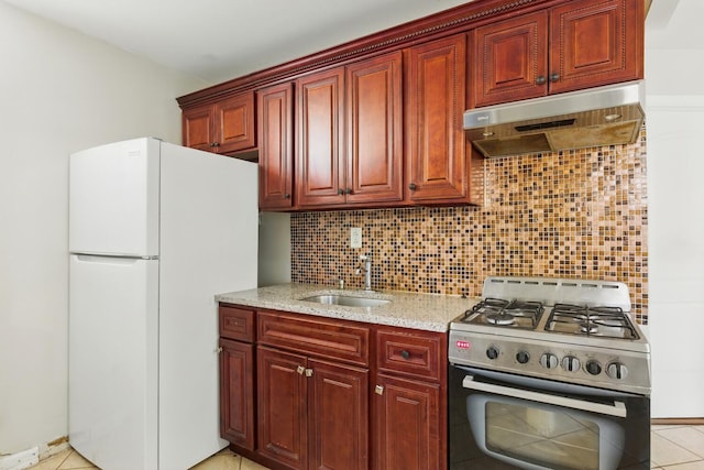 2517 Boston Rd, New York City, NY 10467 - kitchen featuring gas range oven, freestanding refrigerator, under cabinet range hood, and backsplash