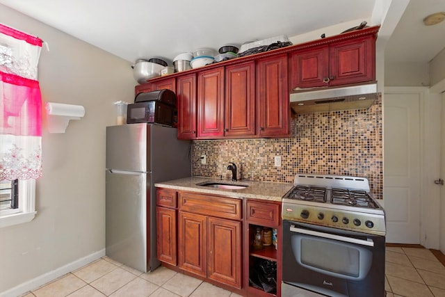 2517 Boston Rd, New York City, NY 10467 - kitchen with appliances with stainless steel finishes, under cabinet range hood, light tile patterned flooring, tasteful backsplash, and reddish brown cabinets