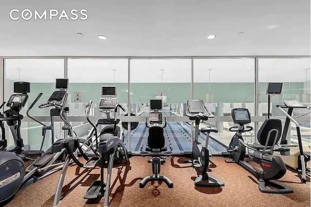 235 E 40th St Unit 11G, New York City, NY 10016 - exercise room featuring a wall of windows, carpet flooring, healthy amount of natural light, and recessed lighting