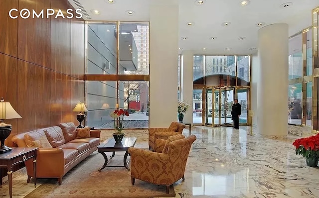 235 E 40th St Unit 11G, New York City, NY 10016 - building lobby with recessed lighting, a towering ceiling, and wood walls