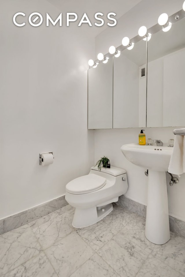 235 E 40th St Unit 11G, New York City, NY 10016 - half bath featuring marble look tiles and baseboards