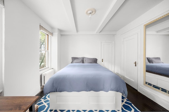 325 W 45th St Unit 312, New York City, NY 10036 - bedroom featuring radiator, wood finished floors, and beamed ceiling