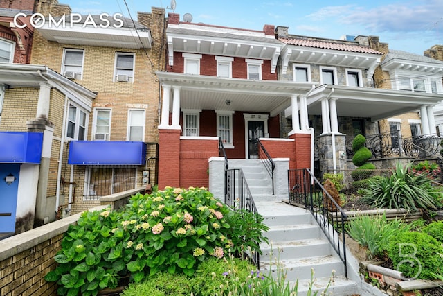 27-12 Ditmars Blvd, New York City, NY 11105 - townhome / multi-family property with brick siding, a porch, and cooling unit
