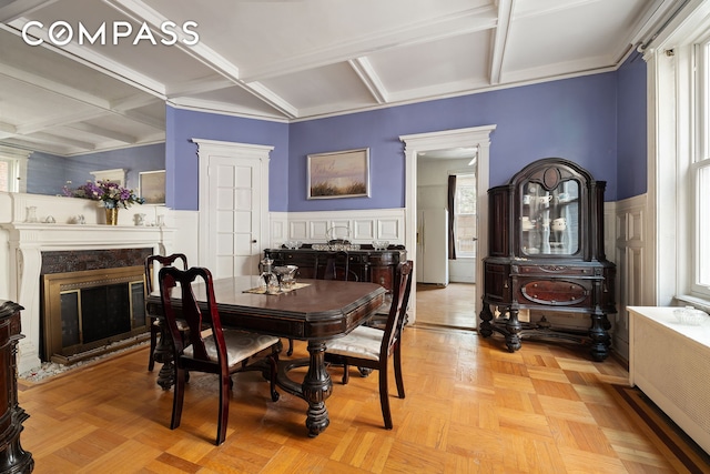 1387 Union St, New York City, NY 11213 - dining room featuring coffered ceiling, a fireplace, plenty of natural light, wainscoting, and a decorative wall